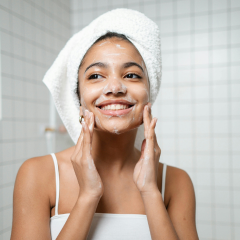 Woman cleansing face for glowing skin
